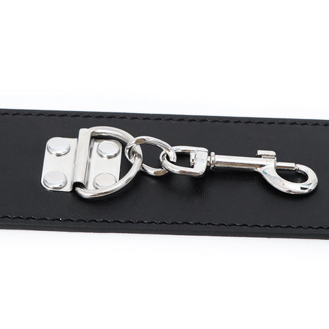 Close-up of the metal clasp on Midnight Desire leather handcuffs, part of a sexy adult bondage set.